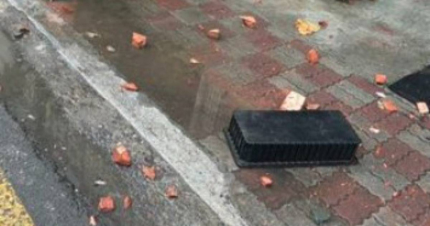 高雄有1名住戶站在民宅3樓陽台，甚至朝外狂丟磚塊及雜物，警消使用雲梯車將他救下。（圖／翻攝畫面）