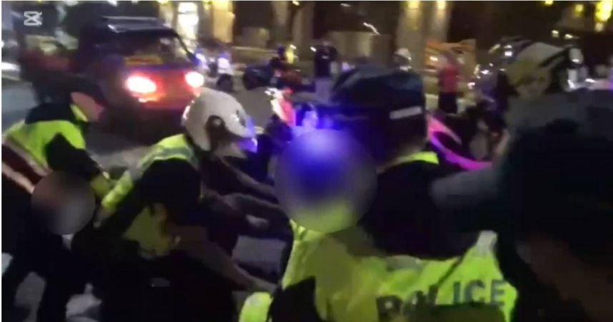 黑衣男酒後失序欲揮拳打人，警方見狀立刻上前攔阻避免衝突發生。（圖／翻攝畫面）