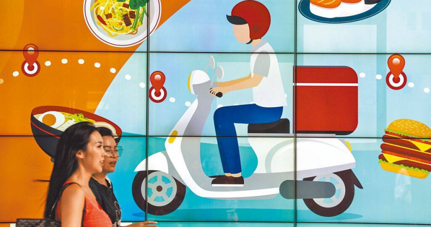 5月景氣燈號從原本代表景氣趨熱的黃紅燈，轉為象徵穩定的綠燈。圖為民眾經過百貨公司外的廣告牆。（圖／報系資料照）