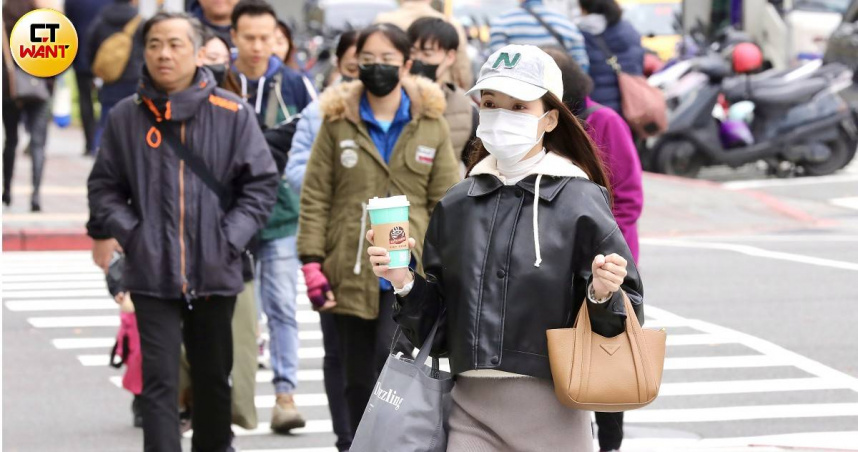 大陸冷氣團影響，全台多地出現體感低溫，街頭民眾瑟縮禦寒。（圖／方萬民攝）