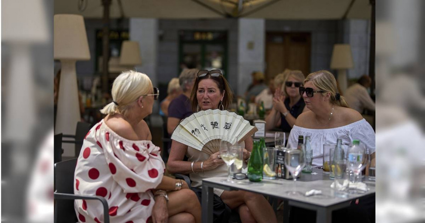 熱浪席捲歐洲多國，造成多起悲劇。圖為今年7月1日，西班牙馬德里一名女子在一家餐廳露台上用扇子給自己降溫。 （圖／達志／美聯社）