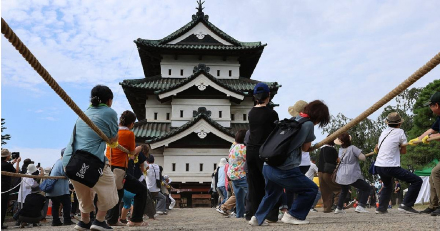 日本青森縣古蹟弘前城天守閣因地震受損，當局號召約1800人以古法合力拉繩。（圖／達志／美聯社）