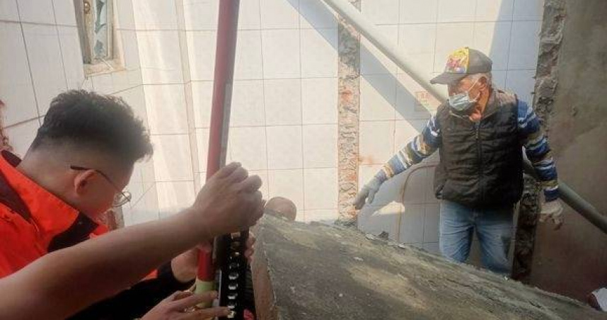 拆屋工人遭磚牆壓住，消防急救脫困。（圖／翻攝畫面）