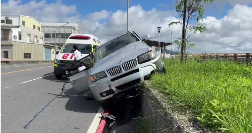 BMW休旅車逆向衝上台東市仁義北路堤防邊坡，車輛傾斜卡在邊坡上引起圍觀。（圖／翻攝畫面）