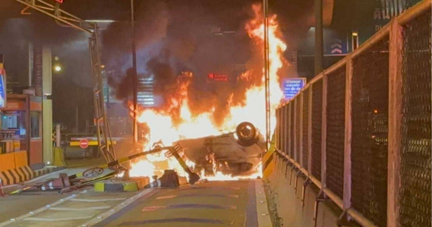 一輛本田小客車於泰國曼谷洽恩瓦塔那1號收費站翻覆並起火，所幸駕駛自行脫困、僅受輕傷。（圖／翻攝自KhaoSod）