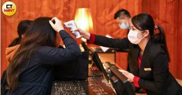 新冠肺炎重創旅館業，櫃台人員位住宿旅客量測體溫，做好防疫工作。（圖∕張文玠攝）