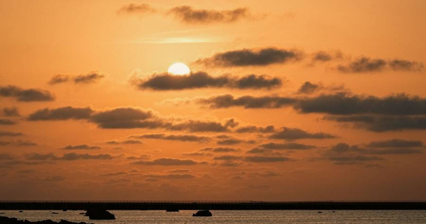 夕陽落入宮古島佐和田之濱的海面，橘金色光暈映照海岸線之美。（圖片提供／星宇航空）