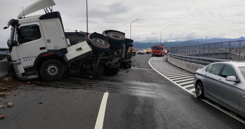 43歲司機國道過彎失控砂石車整輛翻覆砂石灑滿路。（圖 ／翻攝畫面）