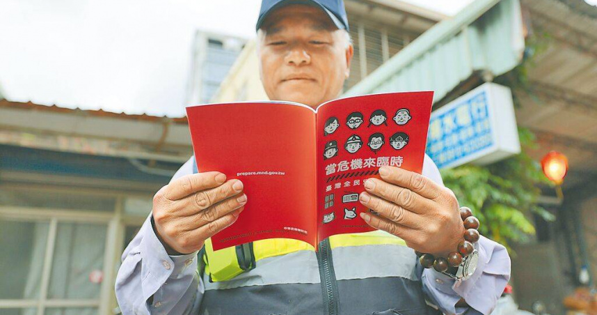 新版全民國防手冊《當危機來臨時：台灣全民安全指引》，日前展開家戶普發作業；圖為民眾領取翻閱。（圖／中國時報郭吉銓攝）
