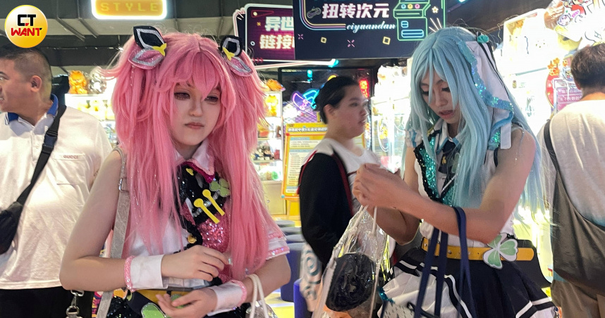周六中午，這一對櫻花粉及湖水綠長髮綁上雙馬尾的美少女，揹著痛包到深圳二次元小鎮打日本太鼓遊戲機。剛上高三的她們說，cosplay「初音未來」很紓壓。（圖／何曼卿攝）