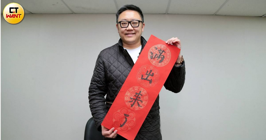 台北市松山信義區市議員參選人滿志剛用自己寫的書法春聯，祝福民眾新年快樂，錢財「滿出來了」。（圖／周志龍攝）