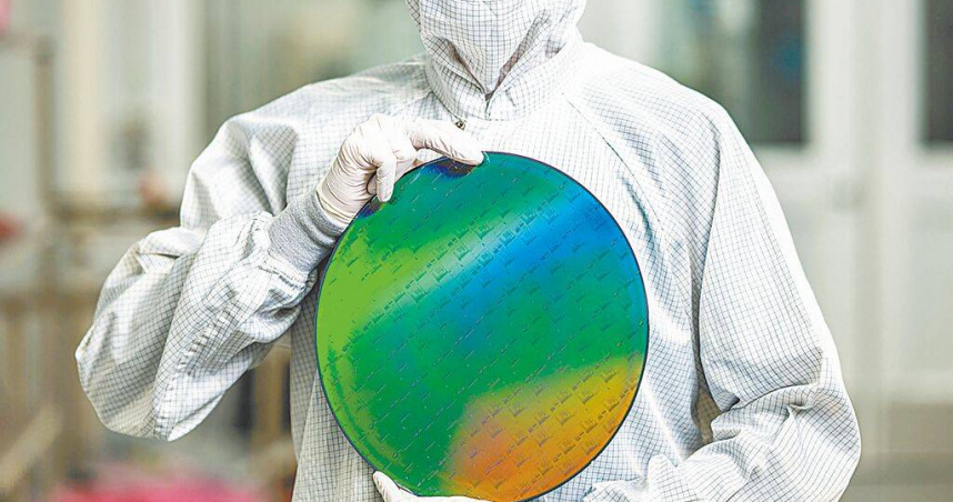 美國政府醞釀向半導體開徵新一輪關稅，據美國半導體行業協會（SIA）估算，關稅每提高1％，晶圓廠建設成本將增加0.64％。圖為一名科技廠員工，手持一片矽晶圓。（圖／達志／路透社）