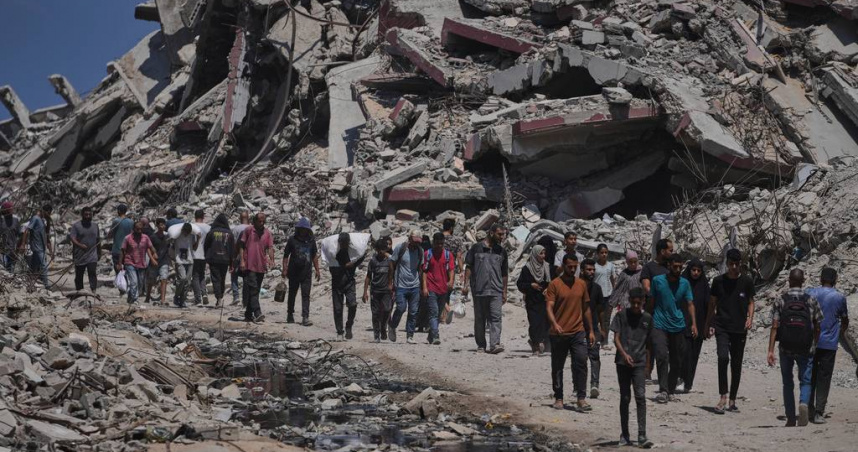 巴勒斯坦人在加薩走廊北部搬運從車隊卸下的人道援助物資。（圖／達志／美聯社）