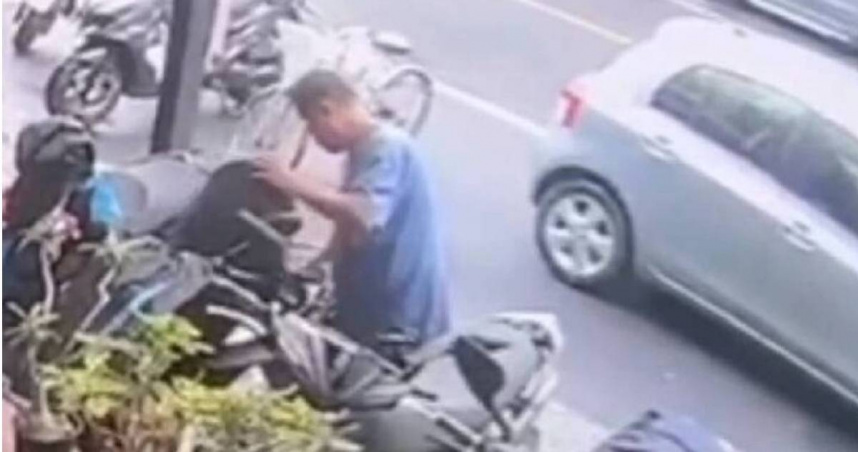 屏東某間養生館前停放的機車，車主因未拔鑰匙遭竊賊撬開座椅，進而偷走錢包和1.7萬元。（圖／翻攝畫面）