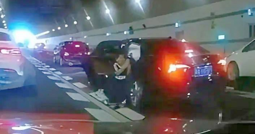 男童在隧道中下跪求路人救母。（圖／翻攝自網易新聞）