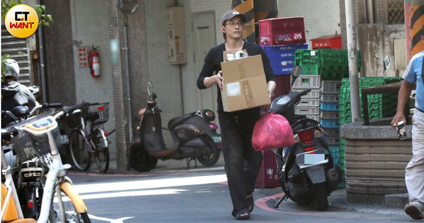 張立昂拿著一箱回收物、一袋垃圾走到巷口。（圖／本刊攝影組）
