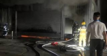 雲林婚宴會館倉庫內車輛30日深夜起火，消防人員以電鋸破門後佈水線灌救，13分鐘內撲滅，2車受損。（圖／翻攝畫面）