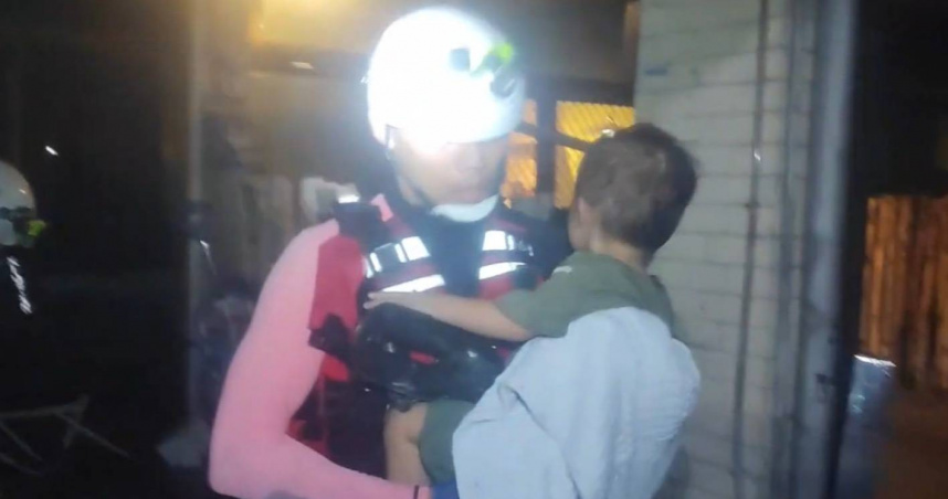 新北特搜24日晚間救出一名2、3歲的孩童，並將孩子抱在懷中輕哄以安撫她的情緒。（圖／新北市消防局提供）