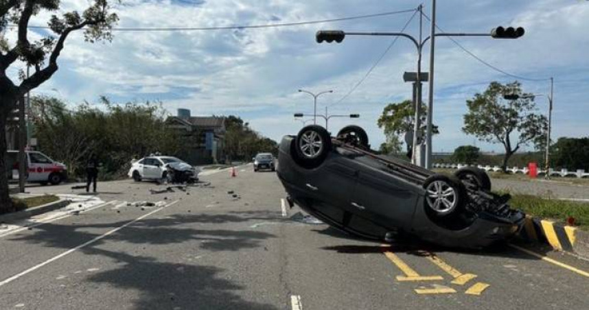苗栗十字路口有轎車闖紅燈，不慎撞上1車後又自撞分隔島，進而翻覆在馬路上。（圖／翻攝畫面）