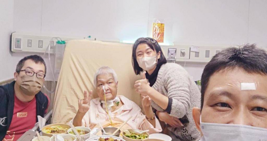 75歲許姓婦人惦記農曆年無法回家圍爐，子女把圍爐餐移師病房，一家人團聚吃飯。（翻攝畫面）