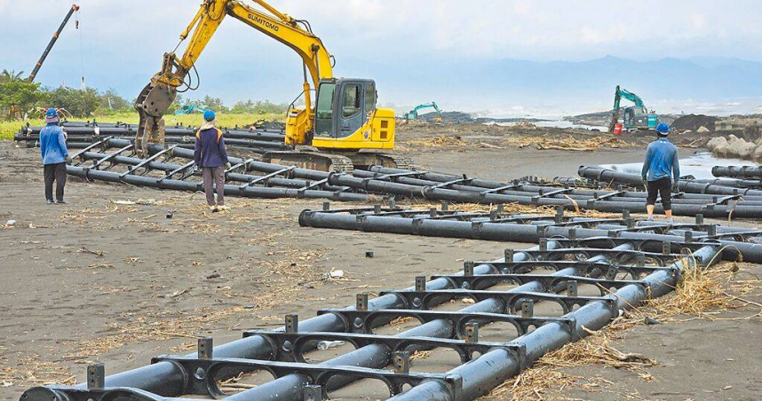 屏東佳冬離岸光電浮台遭丹娜絲颱風吹散，黑色浮台結構體散落南部沿海，旭東公司出動重型機具清除浮台殘骸。（圖／中國時報羅琦文攝）