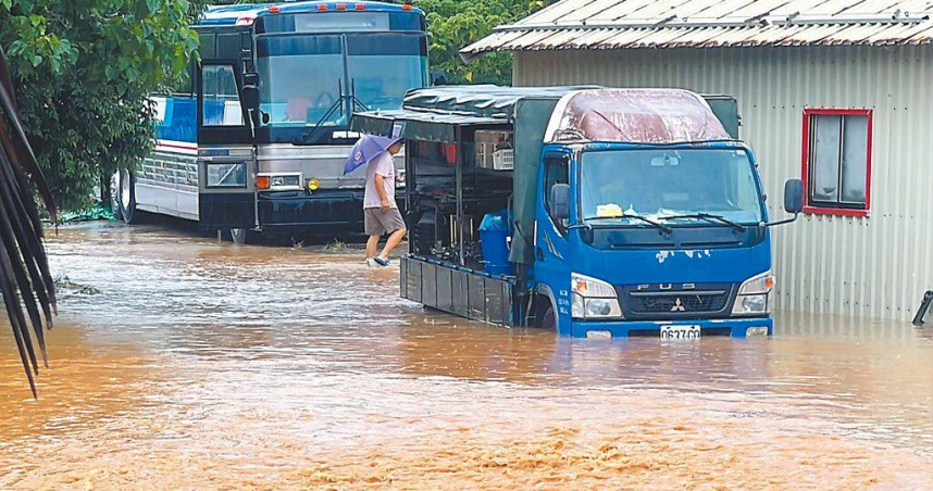 受低壓帶與西南風影響，台東縣大武鄉太湖路排水溝暴漲溢流，積水深及車輪，人車涉水而行，宛如在「陸上黃河」中通行。（圖／中國時報蕭嘉蕙攝）