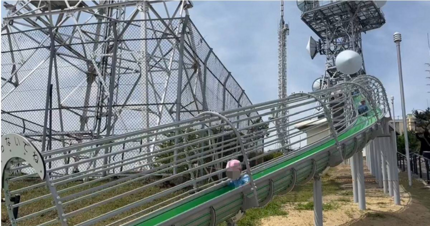 位於日本福岡縣北九州市的皿倉山，今年4月啟用一座巨型溜滑梯遊樂設施，怎料一名30多歲台灣女遊客在溜下滑梯後，竟小腿骨折受傷，當地政府也緊急宣布，暫停使用該遊樂設施。（圖／擷取自X）