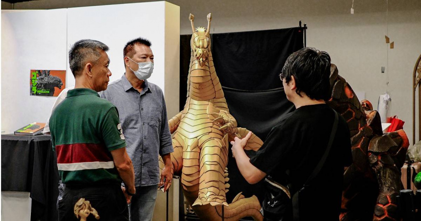 店家「特製庫」以日本的「特攝」為主題，手工製作出一尊瓦楞紙為材料，外觀金黃色，充滿金屬光澤的怪獸，吸引許多目光。左二為台北市文化局長蔡詩萍，左一為龍山文創基地計畫主持人洪文和。（圖／主辦單位提供）