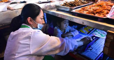 7歲女童陪爸媽市場擺攤「滷味下讀書」!外媒譽:亞洲版哈利波特
