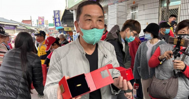 紫南宮主委莊秋安，展示金雞蛋獎品金戒指。（圖／中國時報廖志晃攝）