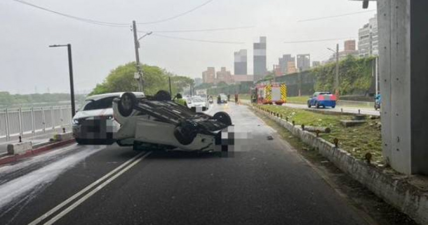 新莊1輛轎車突自撞分隔島「烏龜翻」，造成車上母子2人受傷送醫，疑駕駛恍神惹禍。（圖／翻攝畫面）