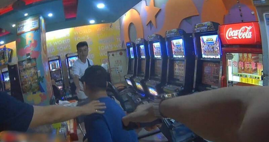 陳姓男子遭橋頭和高雄地檢署通緝,4日在遊藝場打機台時遭警方發現並逮捕。(圖/翻攝畫面)