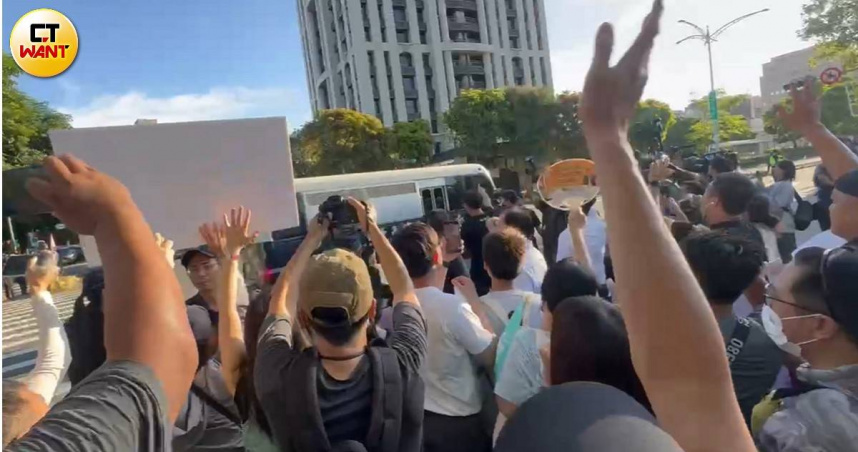 黃國昌帶著小草在愛國西路口揮別囚車，並大喊口號、高舉標語表達支持。（圖／陳柔瑜攝）