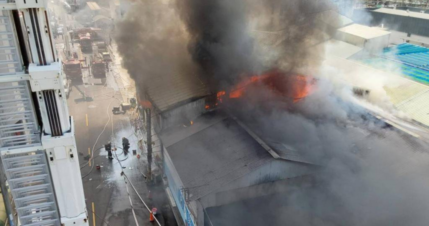 嘉義市僑嘉三街大火濃煙衝天，緊鄰羽球館與民宅驚魂未定。（翻攝畫面）