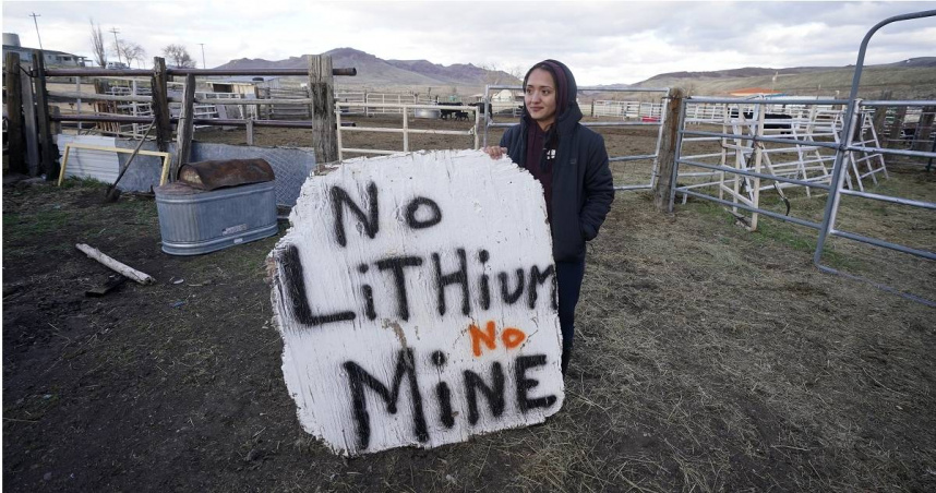 一位來自「麥克德米特堡派尤特與肖肖尼部落」（Fort McDermitt Paiute and Shoshone Tribe）的成員高舉著手繪的大型標語牌，上面寫著「不要鋰礦，不要開採」。（圖／達志／美聯社）