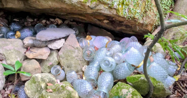 台北市北投區丹鳳山登山步道沿線驚現大量祭拜用蠟燭玻璃瓶，其中有部分蠟燭仍在燃燒。（圖／台北市政府大地處提供）