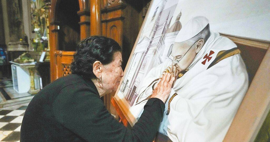 在梵蒂岡宣布教宗方濟各逝世後，民眾在阿根廷的大教堂觸摸已故教宗方濟各的畫像。（圖／美聯社）