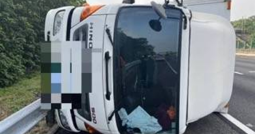 大貨車在國1田尾段自撞護欄後翻覆，橫躺外線車道，26歲黃姓女駕駛肋骨疼痛送醫。（圖／翻攝畫面）