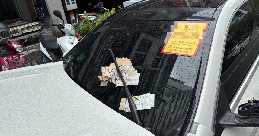 宜蘭礁溪路邊出現一輛白色賓士轎車停在停車格內將近一個月，車頭撞凹、保險桿掉落宛如廢鐵。（圖／民眾提供）