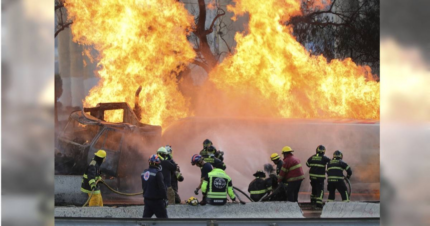 一輛油罐車在高速公路橋下發生爆炸，當地消防員正用水管滅火。（圖／達志／美聯社）