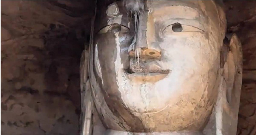 雲岡石窟佛像的眉骨與鼻樑處懸掛著細長冰凌，遠看宛如大佛因受寒而「流鼻涕」。（圖／翻攝自《百度》）