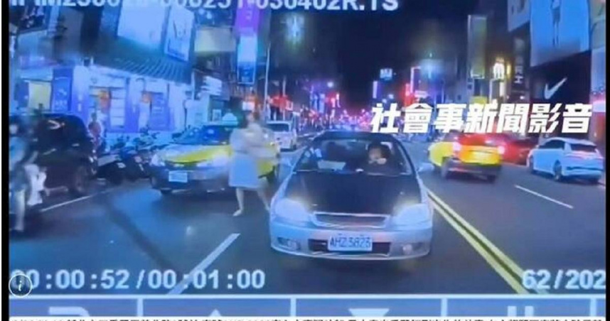駕車男子疑似因夫妻吵架，竟失控在車上動手打小孩，氣得一旁妻子故不得在馬路中間，抱起2名小孩立刻下車。（圖／翻攝社會事新聞影音）