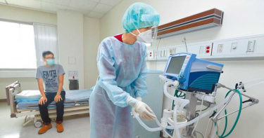 護理人員全副武裝穿上隔離衣接收病患送到負壓病房後，整理呼吸器。（圖／本報資料照片）