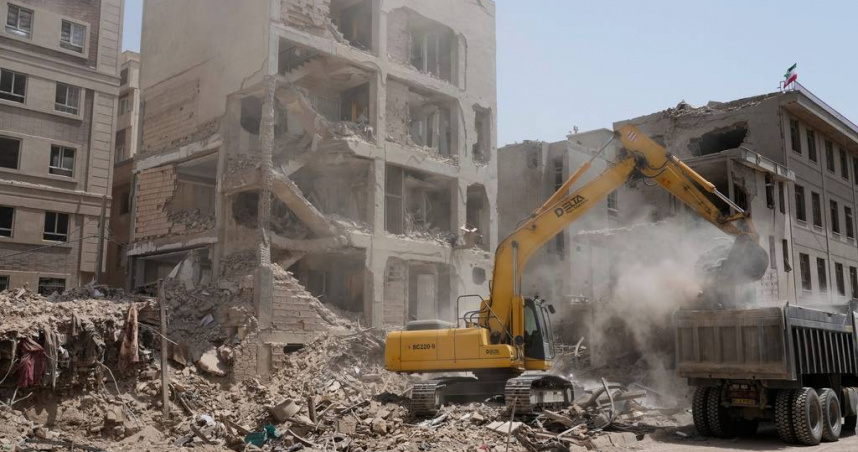一輛挖土機在伊朗首都德黑蘭清理被以色列空襲摧毀的建築物瓦礫。（圖／達志／美聯社）