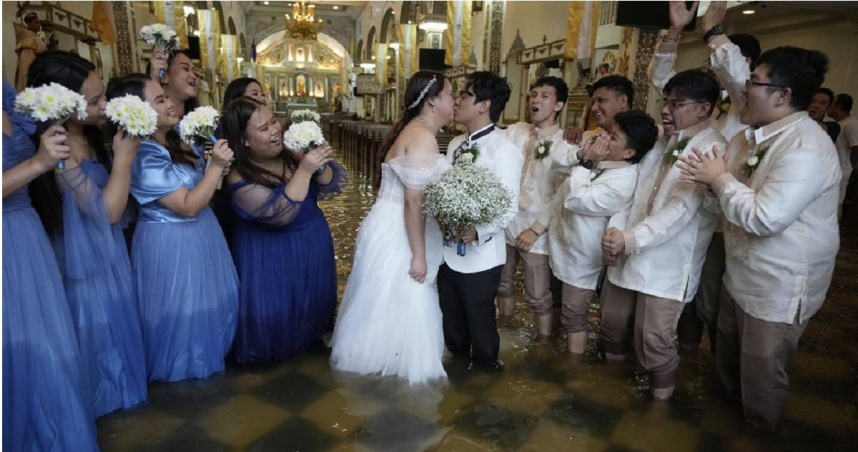 菲律賓新人在積水教堂完成婚禮，新娘婚紗漂浮水面，場面浪漫卻驚險。（圖／達志／美聯社，下同）