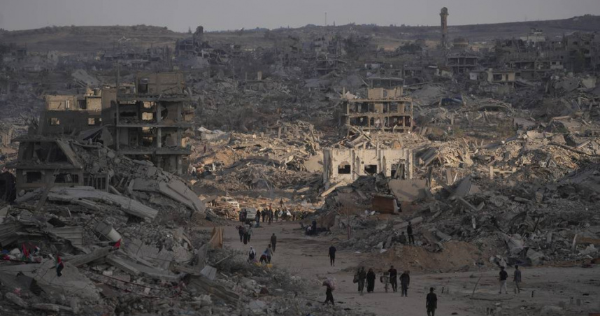 巴勒斯坦人在加薩城被毀的建築物間行走。（圖／達志／美聯社）