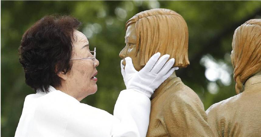 2019年8月14日，韓國慰安婦倖存者李容洙在象徵二戰時期慰安婦問題的女孩雕像揭幕儀式上，觸摸雕像的臉龐。（圖／達志／美聯社）