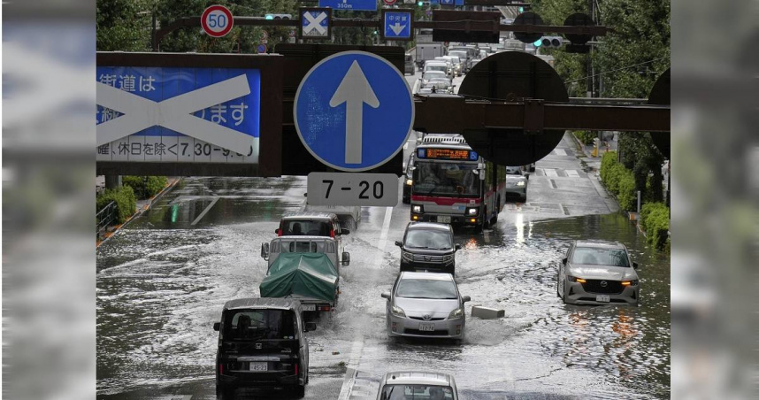 圖為日本東京，車輛駛過因暴雨而被淹沒的道路。（圖／達志／美聯社）