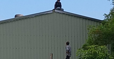 宜蘭壯圍發生哈密瓜竊案，逃逸女移工為躲避警方追查，一度爬上鐵皮屋頂與警方對峙。（圖／翻攝畫面）