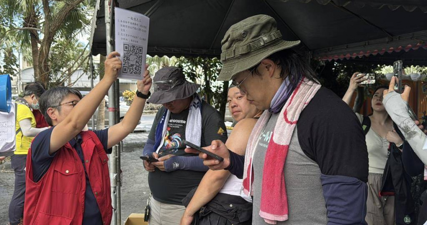 志工到光復車站旁志工分配站，掃描QR Code投保。（圖／中國時報王志偉攝）